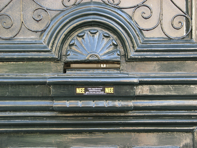 908471 Afbeelding van een kleine liggende metalen brievenbus, in de massieve voordeur van het pand F.C. Dondersstraat ...